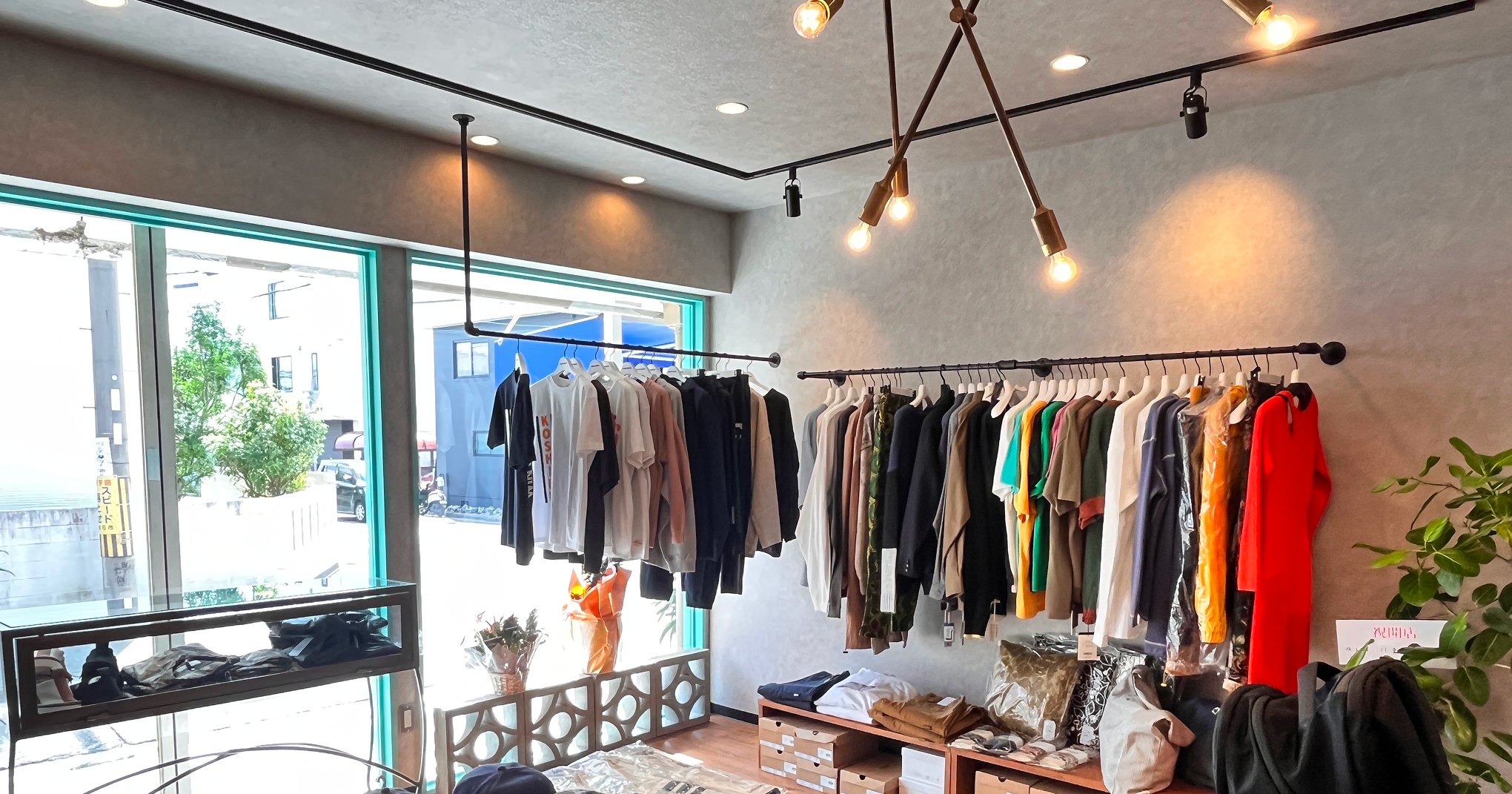 大きな窓から自然光が差し込む店内に、カラフルなTシャツやパーカーが並ぶ。